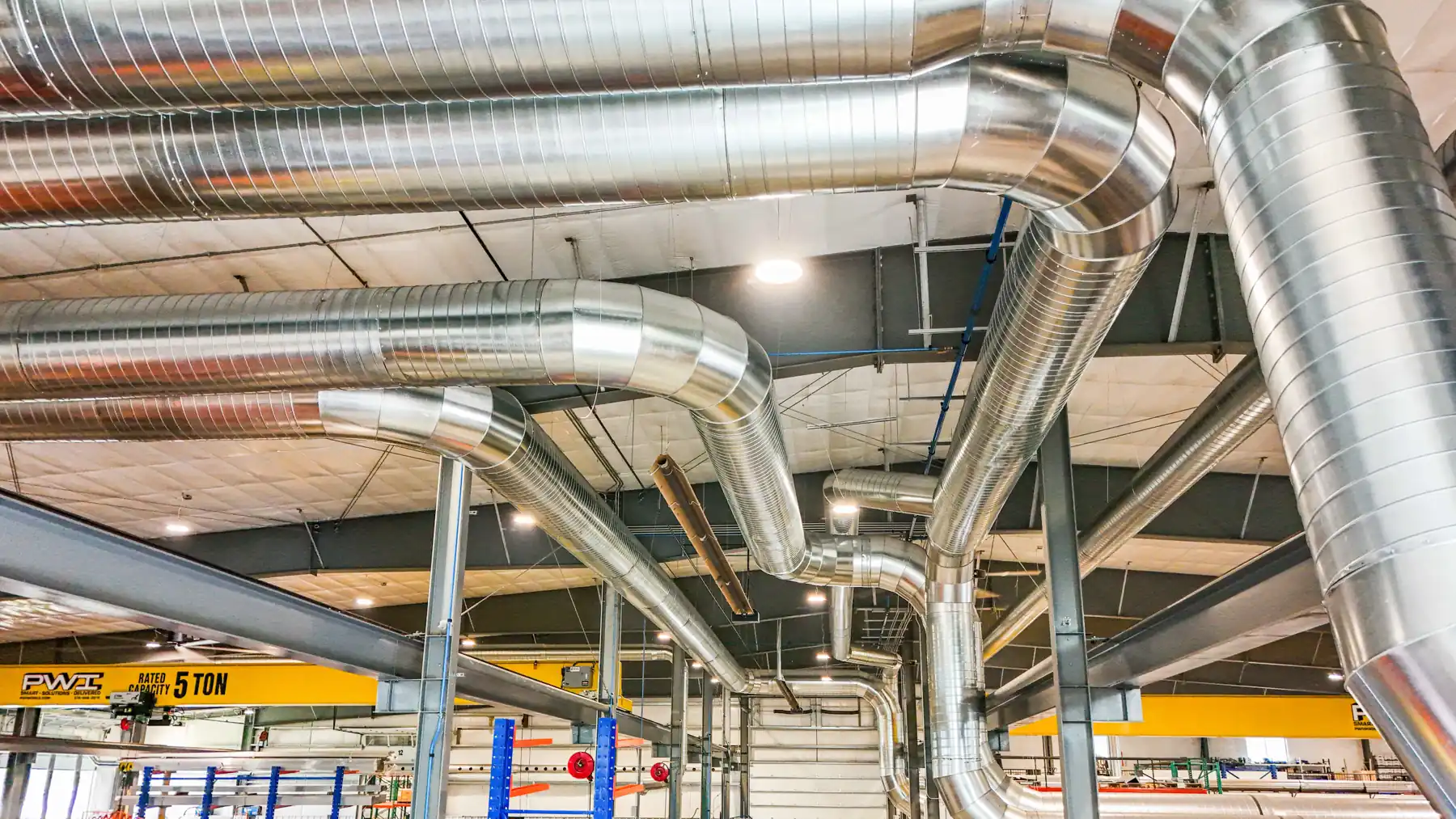Overhead spiral duct network inside Metalium's fabrication shop | CSI Collector Systems - Dust & Fume Collection Systems